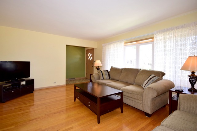 7301 West Roscoe Street Chicago, IL 60634 - Photo 4 of 22 a living room with furniture and a flat screen tv