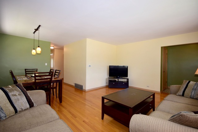 7301 West Roscoe Street Chicago, IL 60634 - Photo 7 of 22 a living room with furniture and a flat screen tv
