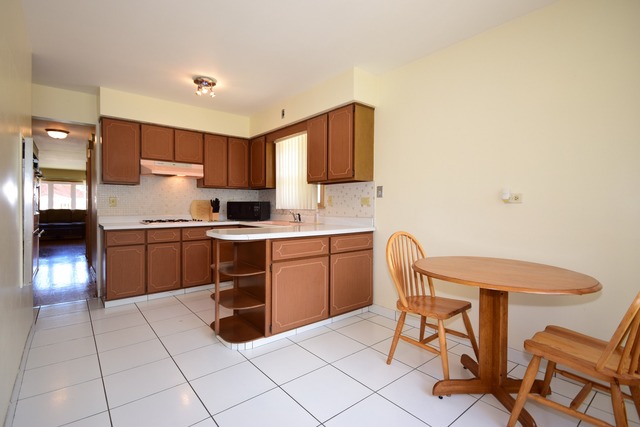 7301 West Roscoe Street Chicago, IL 60634 - Photo 8 of 22 a kitchen with granite countertop a sink cabinets and stainless steel appliances