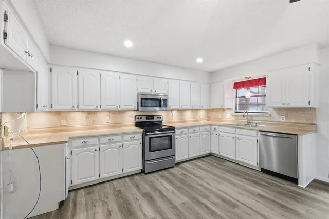 a kitchen with granite countertop white cabinets and white appliances