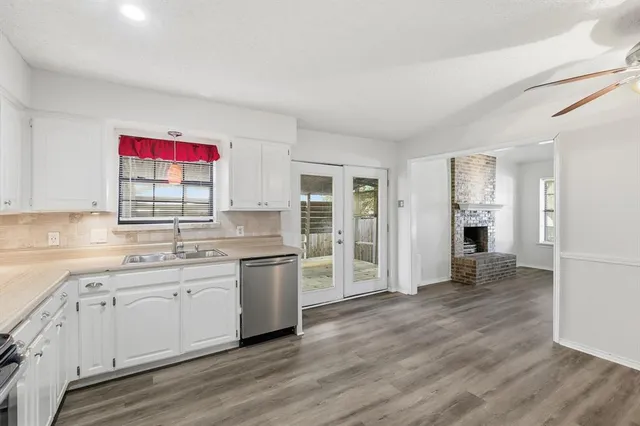 a kitchen with granite countertop a sink cabinets and wooden floor