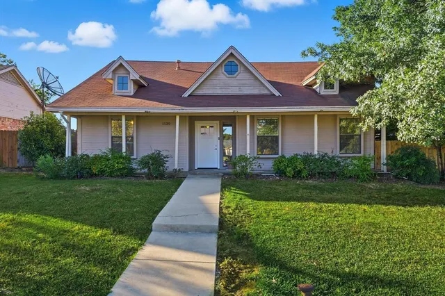 a front view of a house with yard and green space