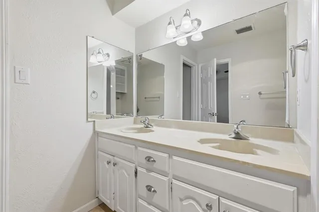 a bathroom with a sink double vanity and a mirror