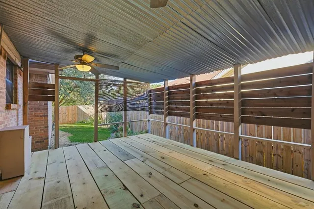 a view of backyard with large trees and wooden fence