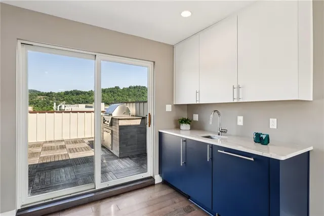 a kitchen with stainless steel appliances granite countertop white cabinets and a window