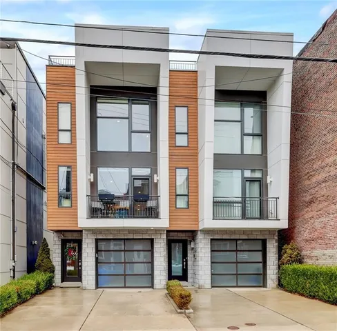 a front view of a brick house with a garage and large windows