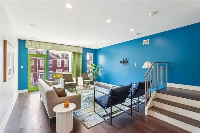 a living room with furniture a rug and a floor to ceiling window
