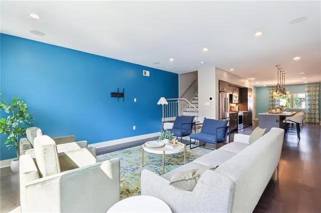 a living room with furniture and a dining table with wooden floor