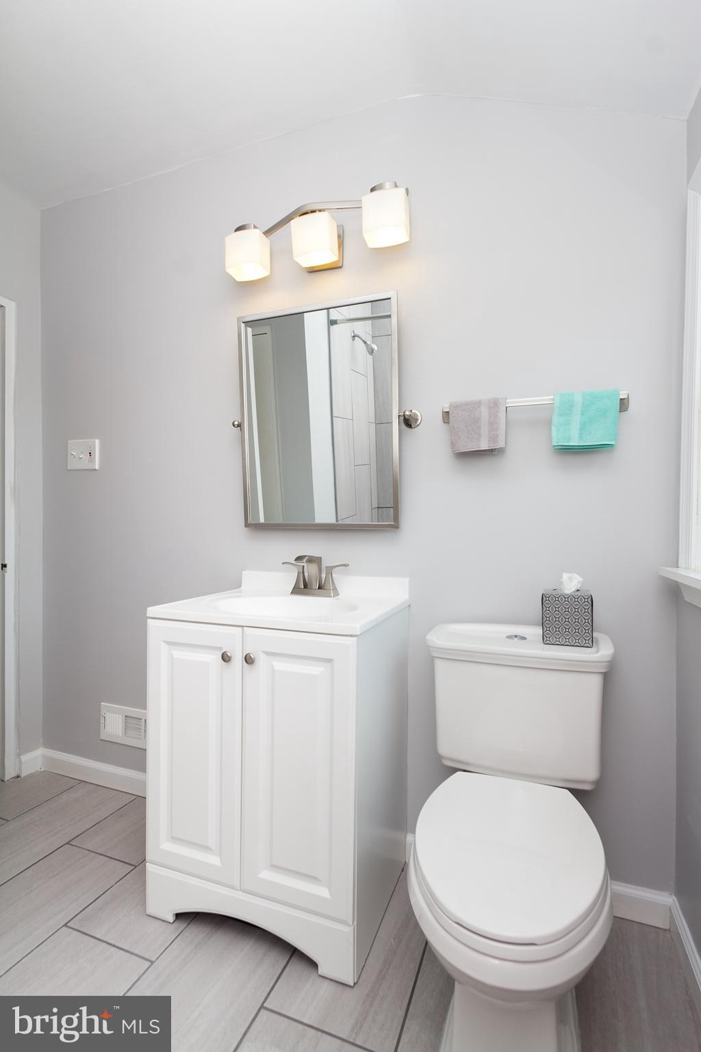 2806 Kirkleigh Road Baltimore, MD 21222 - Photo 5 of 10 a bathroom with a toilet a sink and mirror