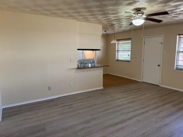 a view of a kitchen with wooden floor and a ceiling fan