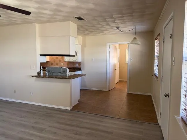 a hallway view with wooden floor and cabinet