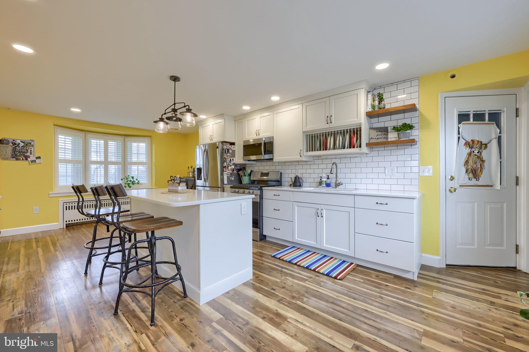 9 Haskell Drive Lancaster, PA 17601 - Photo 11 of 32 a kitchen with stainless steel appliances kitchen island granite countertop a table chairs in it and wooden floors