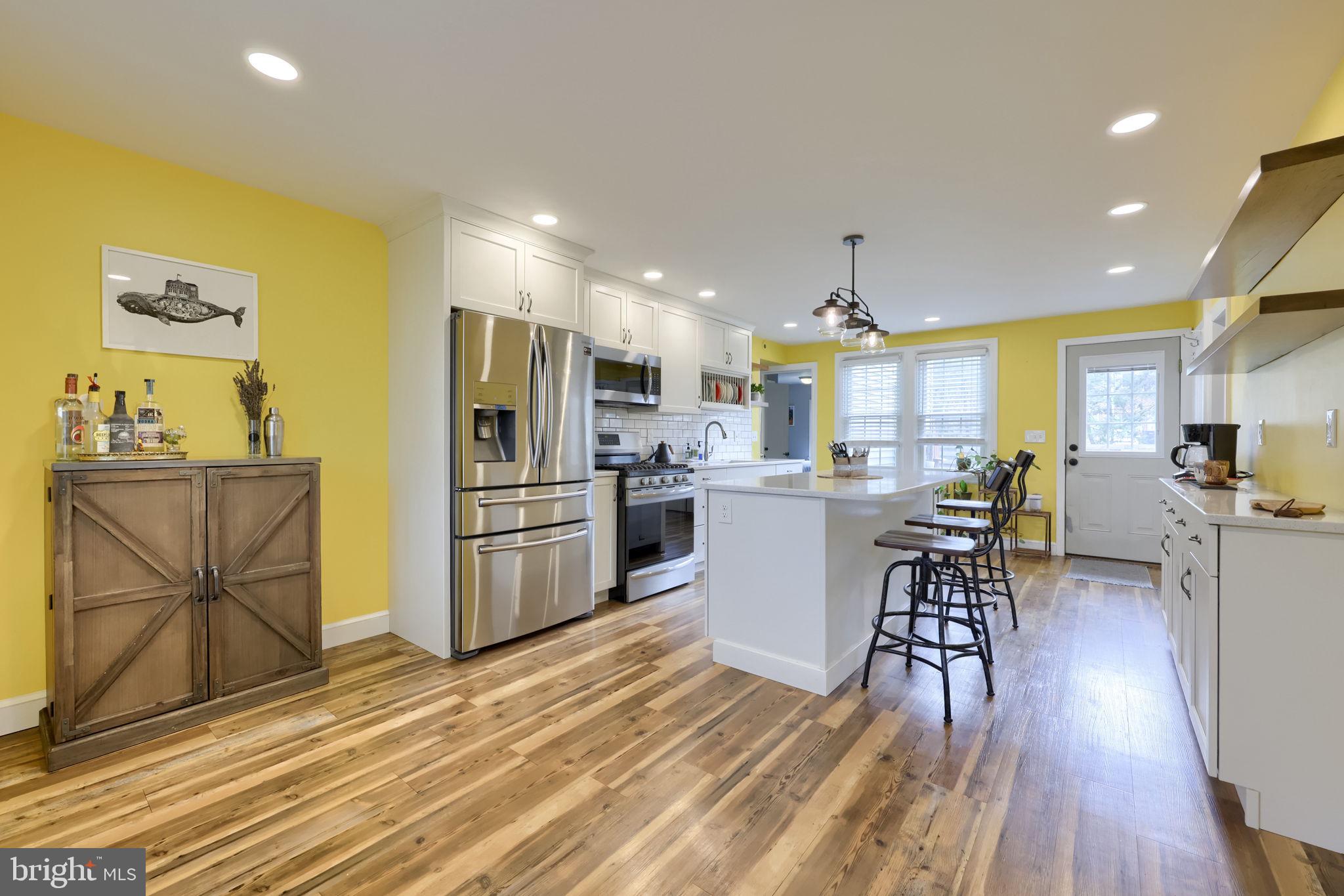 9 Haskell Drive Lancaster, PA 17601 - Photo 15 of 32 a kitchen with stainless steel appliances kitchen island granite countertop a refrigerator a stove top oven and a dining table with wooden floor