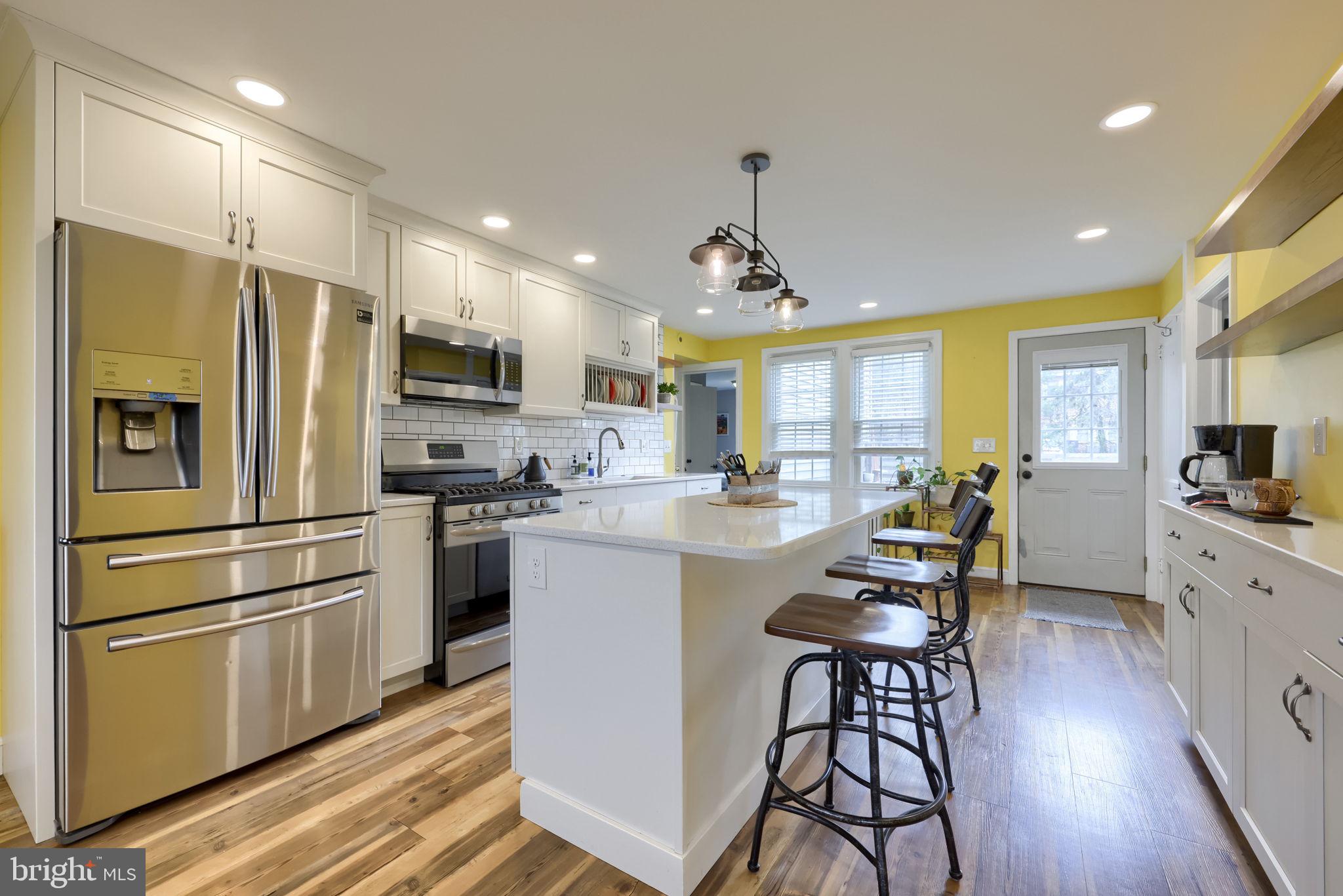 9 Haskell Drive Lancaster, PA 17601 - Photo 16 of 32 a kitchen with stainless steel appliances a refrigerator a stove a sink a dining table and chairs with wooden floor