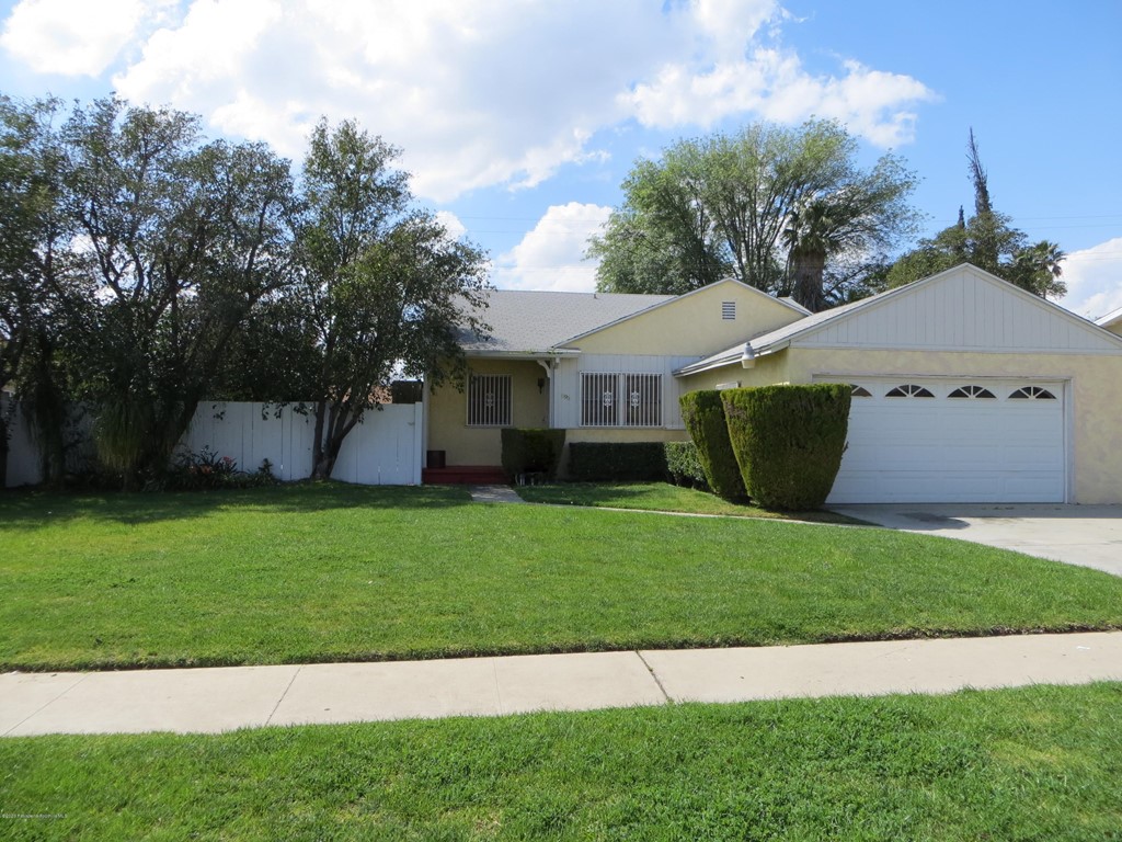 a front view of a house with a garden and yard