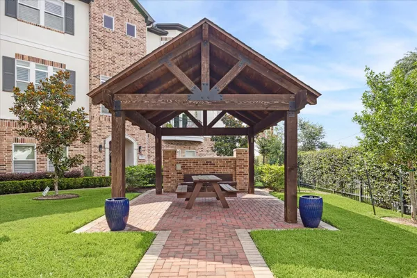 a view of a patio with table and chairs potted plants and a large tree