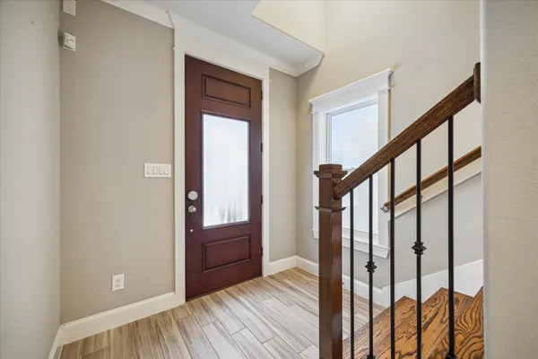 a view of front door with wooden floor and stairs