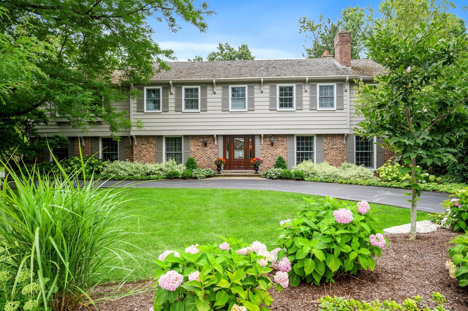 2002 Brandon Road Glenview, IL 60025 - Photo 1 of 37 a front view of a house with a yard and fountain in it
