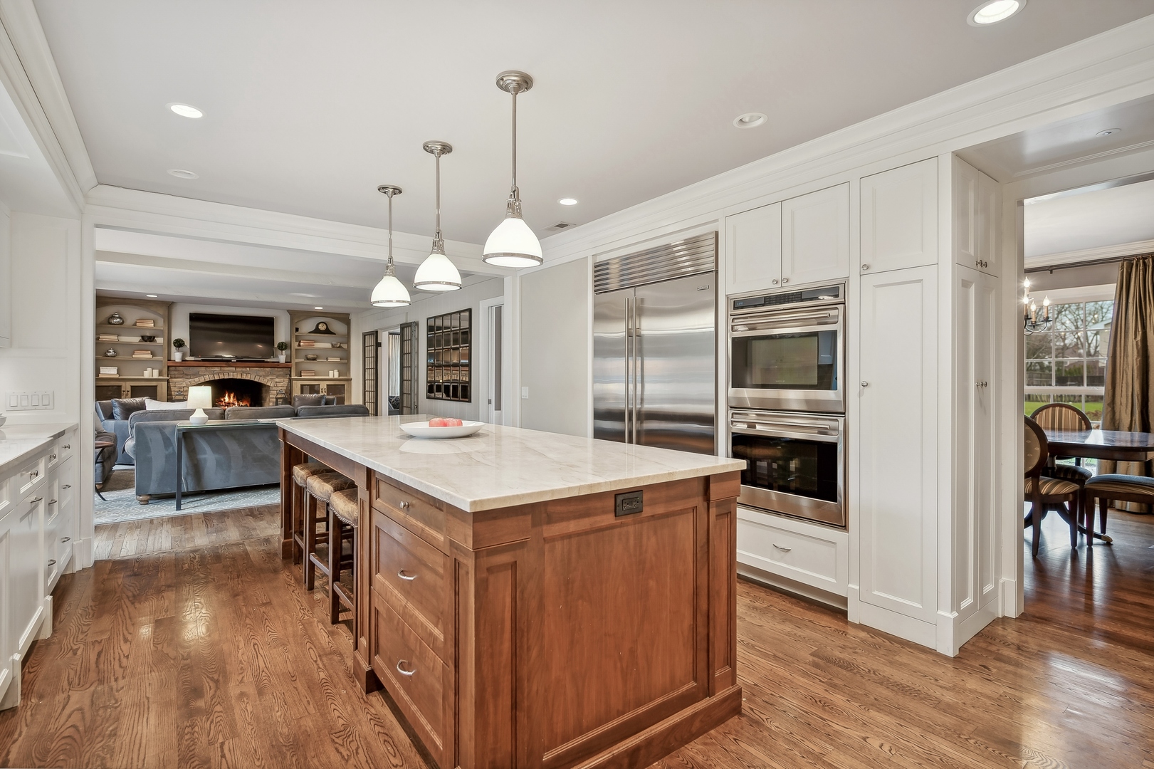 2002 Brandon Road Glenview, IL 60025 - Photo 11 of 37 a kitchen with stainless steel appliances a stove center island wooden floor and a view of living room