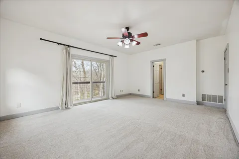 a view of a livingroom with a ceiling fan and window