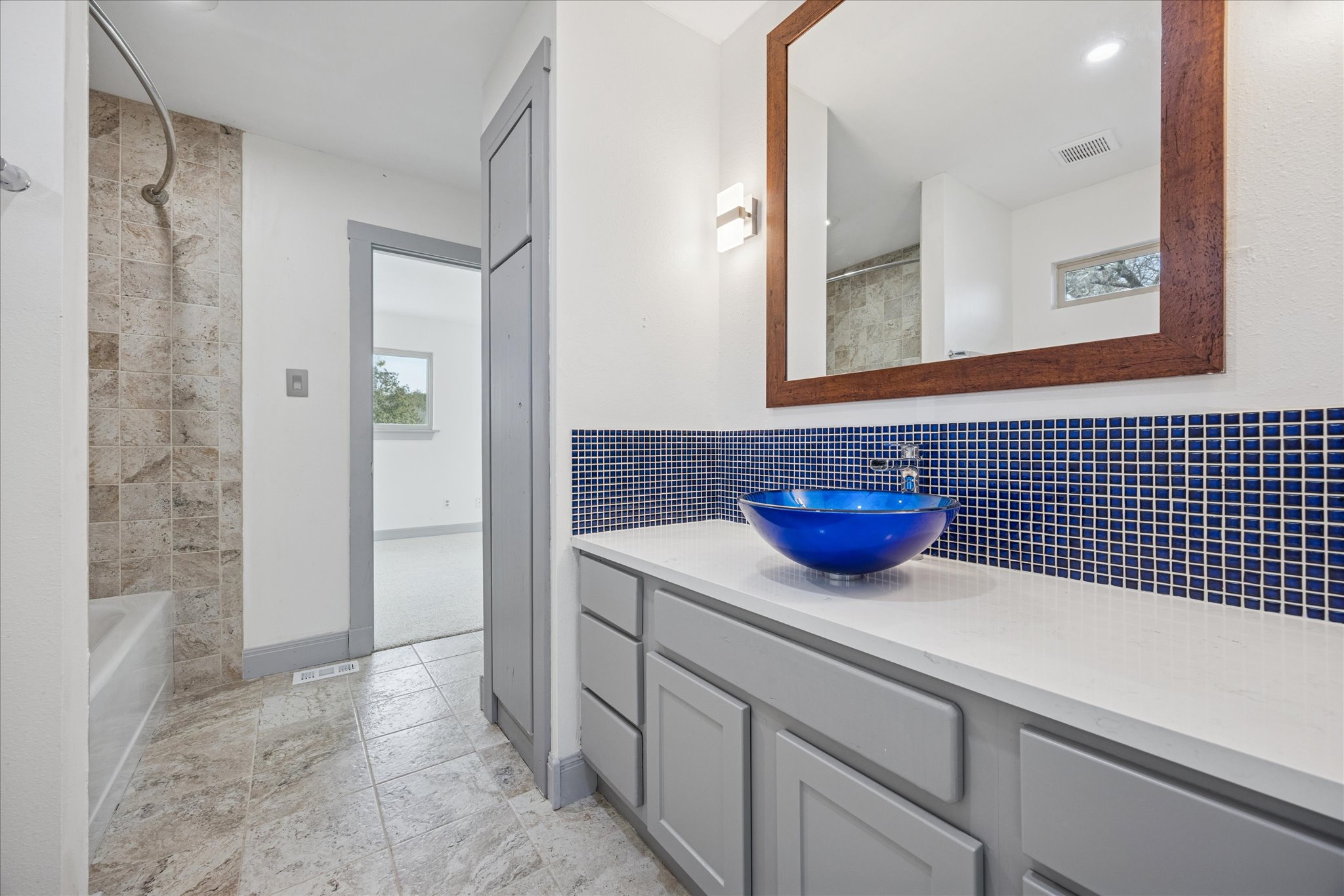 13918 Hummingbird Lane Austin, TX 78732 - Photo 18 of 32 a view of a bathroom with a sink a mirror and a shower