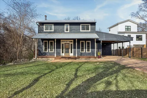 a view of house with yard and tree in the background