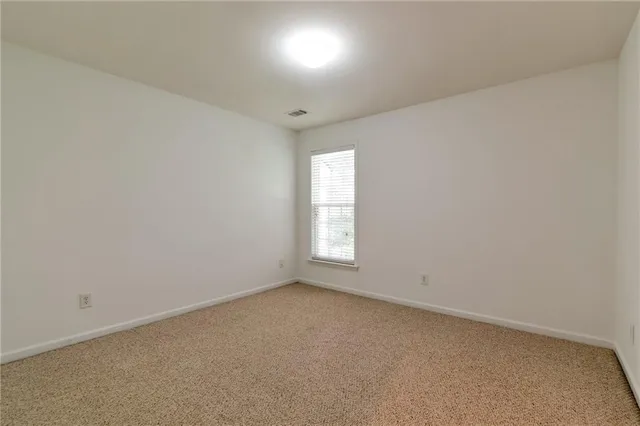 an empty room with a window and wooden floor