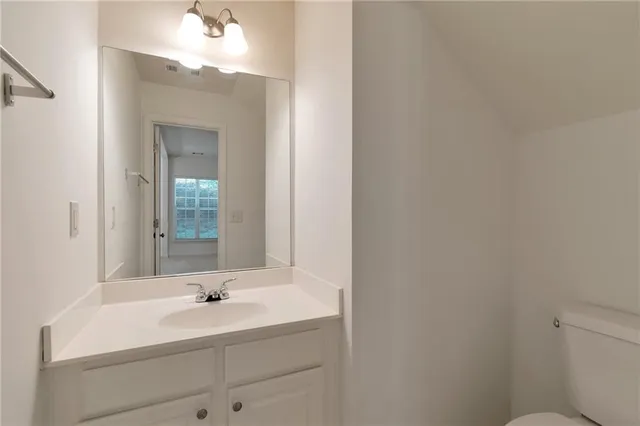 a bathroom with a toilet a sink and mirror