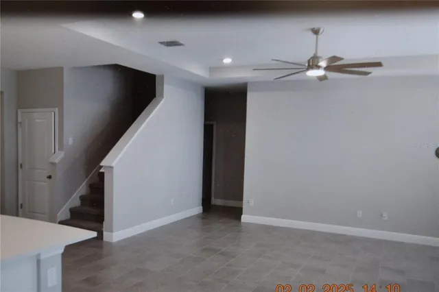 wooden floor in an empty room with a ceiling fan