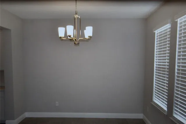 a view of a room with a hanging light and kitchen