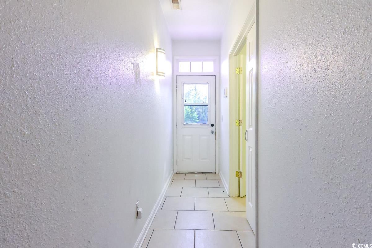 2191 Jasmine Road Loris, SC 29569 - Photo 35 of 40 Hallway with light tile patterned floors, baseboards, and a textured wall
