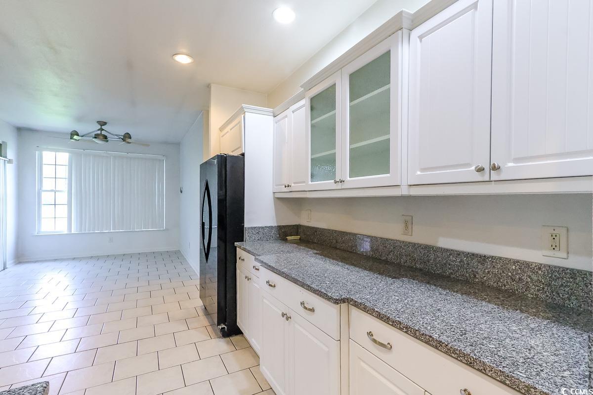 2191 Jasmine Road Loris, SC 29569 - Photo 10 of 40 Kitchen with freestanding refrigerator, glass insert cabinets, white cabinetry, dark stone countertops, and recessed lighting