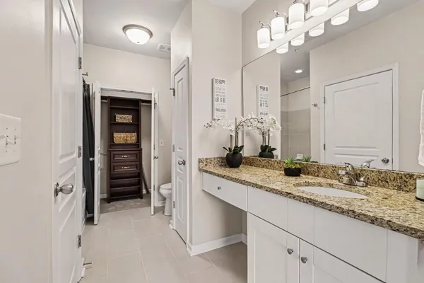 a bathroom with a granite countertop sink a mirror and a shower