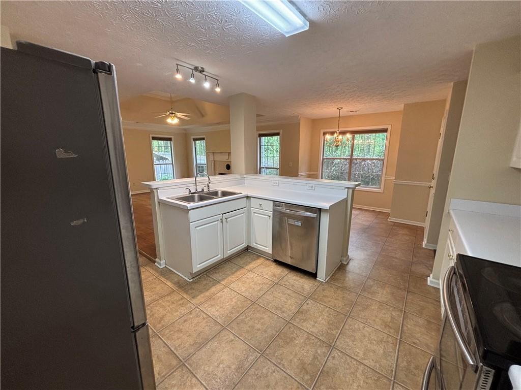 170 Gibson Way Covington, GA 30016 - Photo 27 of 50 a kitchen with stainless steel appliances granite countertop a sink stove and refrigerator