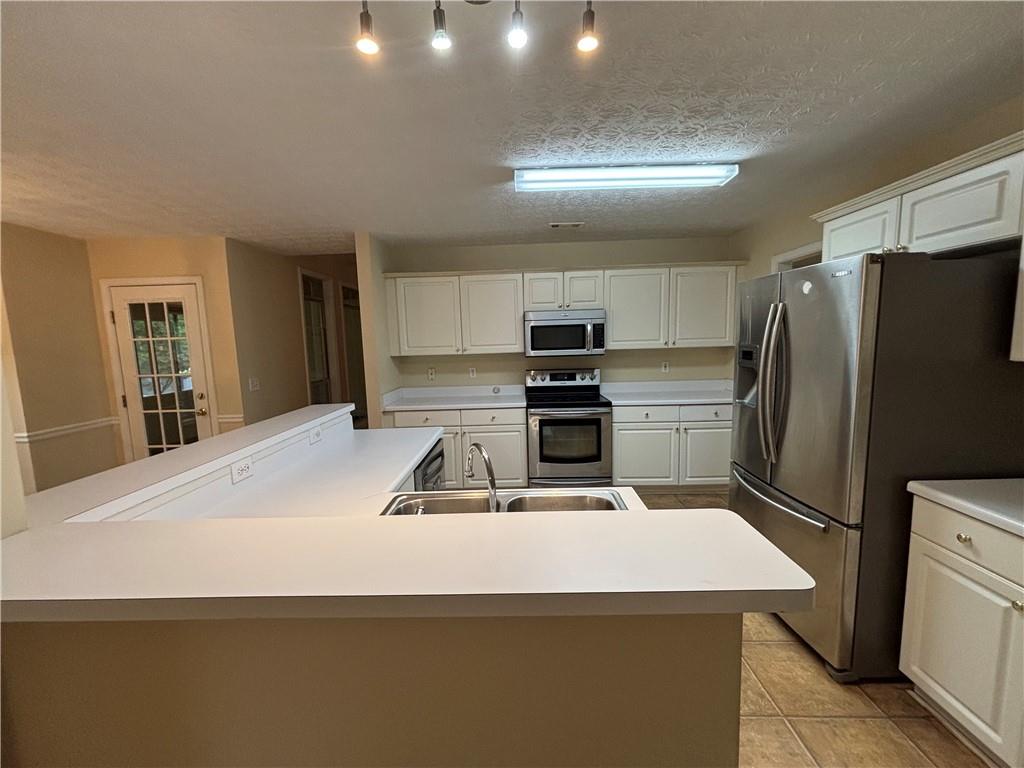 170 Gibson Way Covington, GA 30016 - Photo 33 of 50 a kitchen with stainless steel appliances a refrigerator and a stove