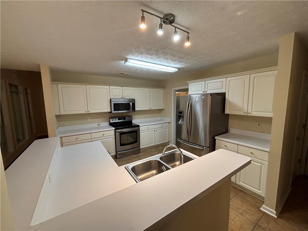 170 Gibson Way Covington, GA 30016 - Photo 35 of 50 a kitchen with granite countertop a refrigerator and a stove top oven