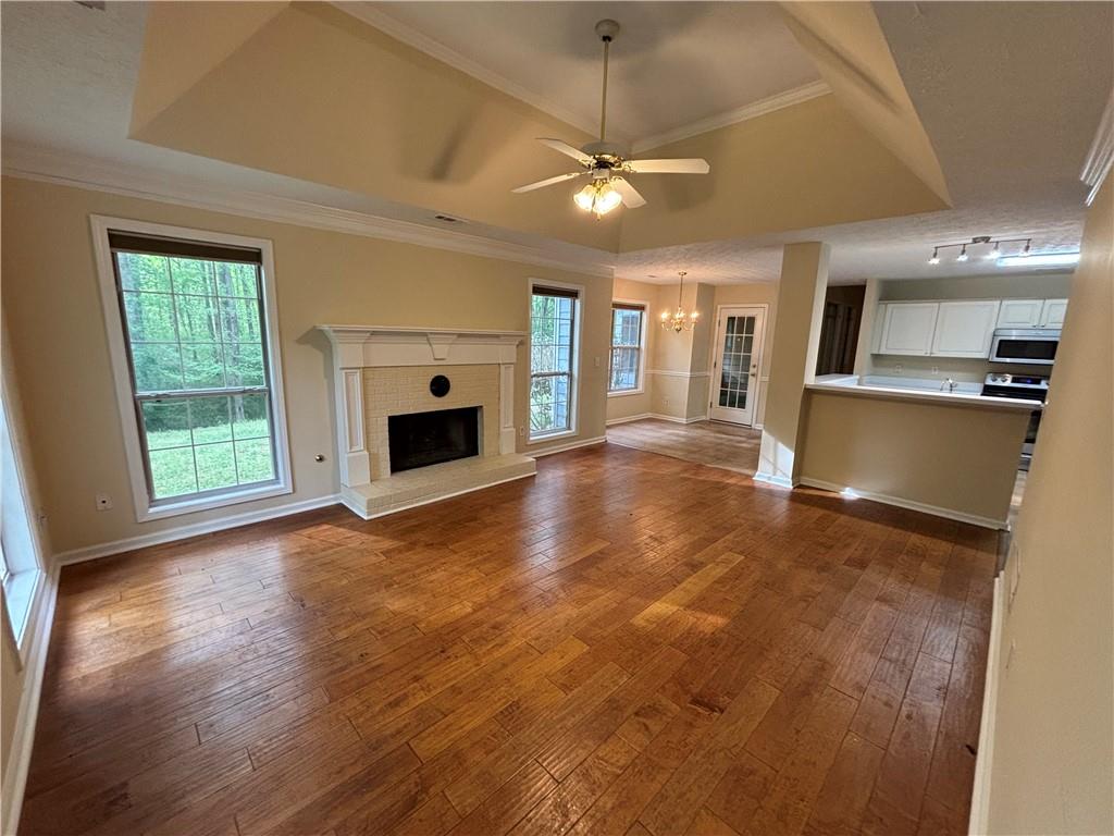170 Gibson Way Covington, GA 30016 - Photo 44 of 50 an empty room with wooden floor fireplace and windows