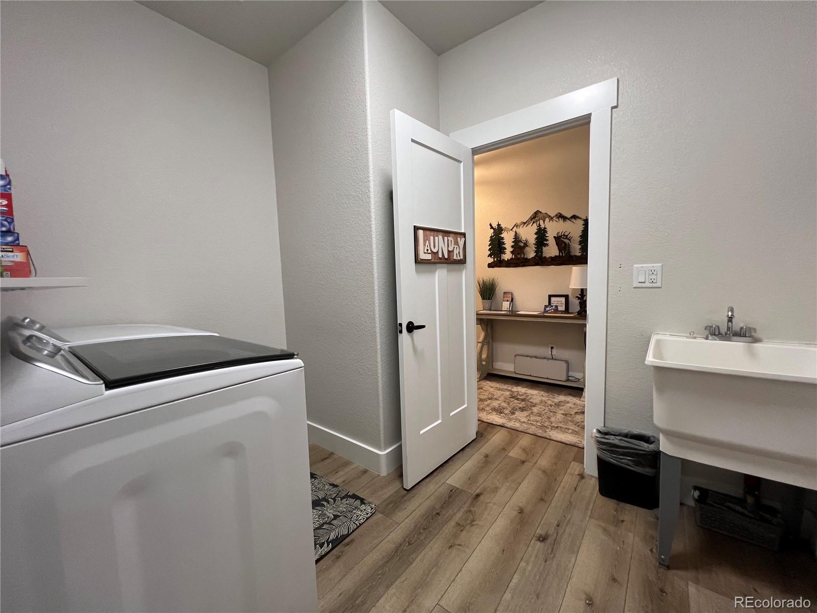 348 Duesouth Road Florissant, CO 80816 - Photo 17 of 28 a view of washer and dryer with wooden floor
