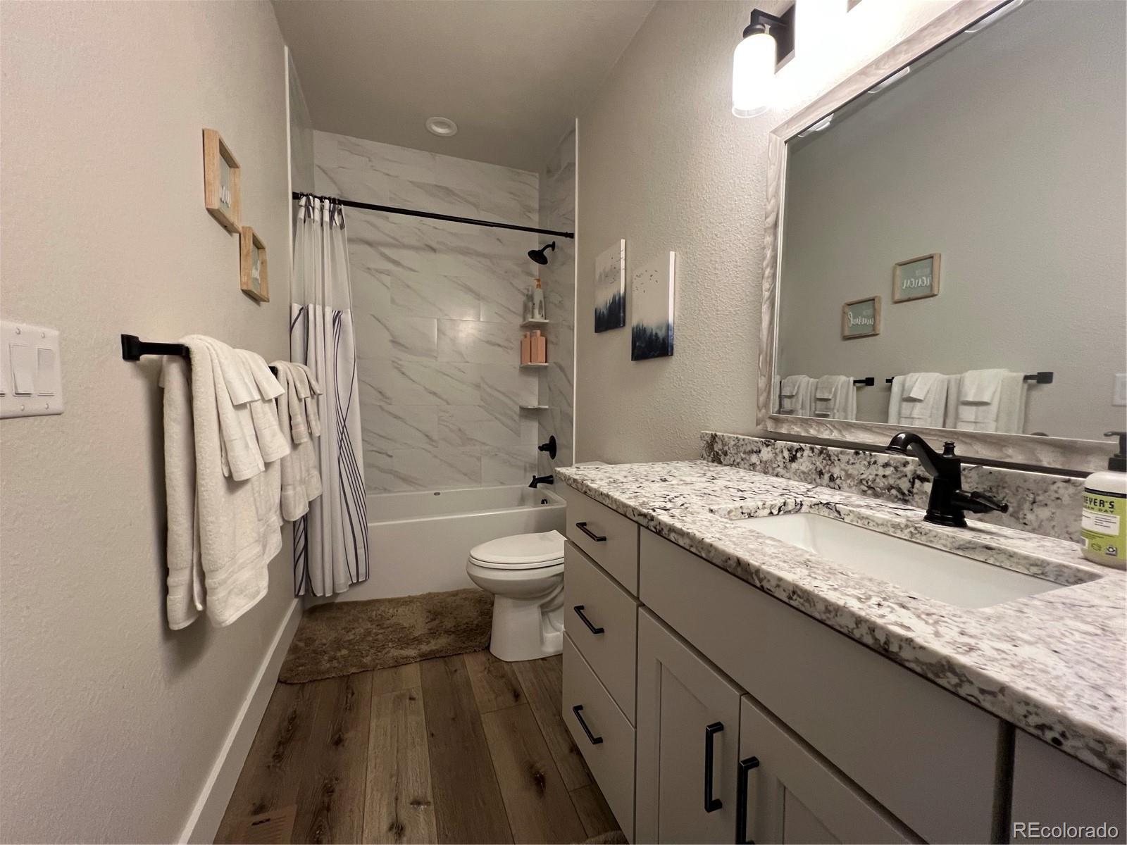 348 Duesouth Road Florissant, CO 80816 - Photo 23 of 28 a bathroom with a granite countertop sink toilet and shower