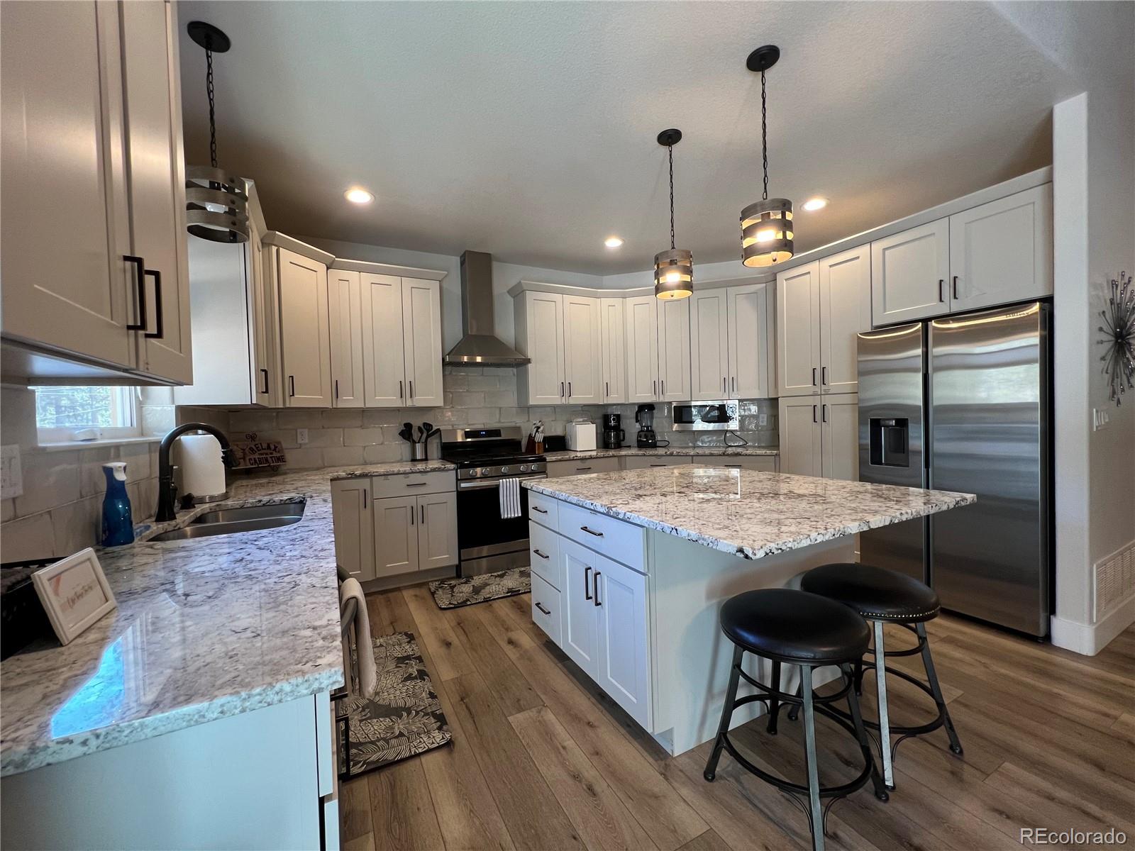 348 Duesouth Road Florissant, CO 80816 - Photo 5 of 28 an open kitchen with granite countertop kitchen island wooden floor center island stainless steel appliances and furniture