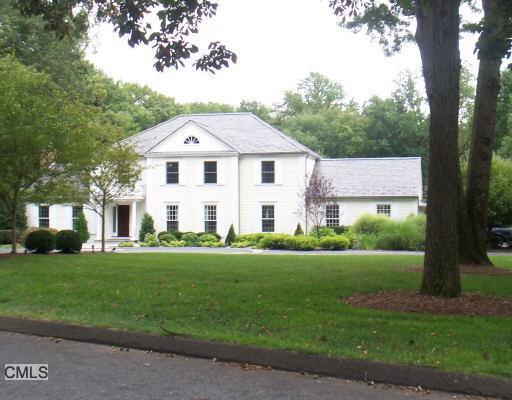 87 Ridge Common Fairfield, CT 06824 - Photo 1 of 1 a view of a white house with a big yard and large trees