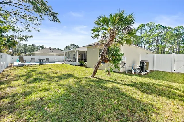 a view of a house with a backyard and a tree