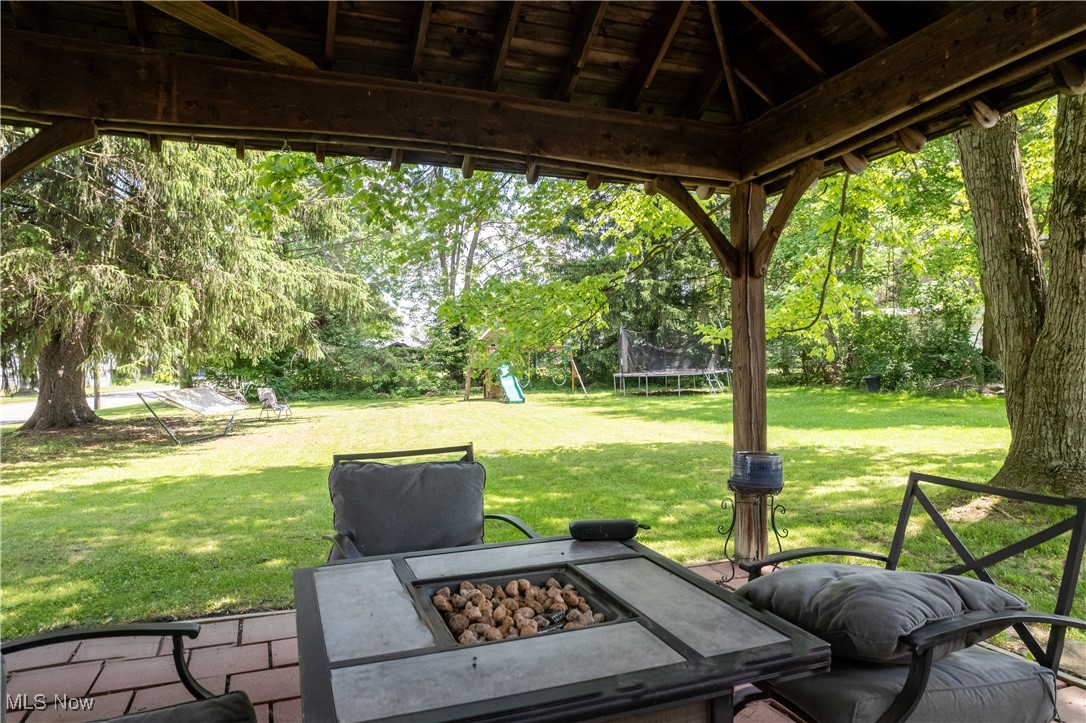 167 Taylor Road Barberton, OH 44203 - Photo 9 of 40 View of patio with a gazebo, a fire pit, and a trampoline