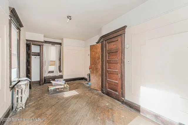 an empty room with mirror and a window