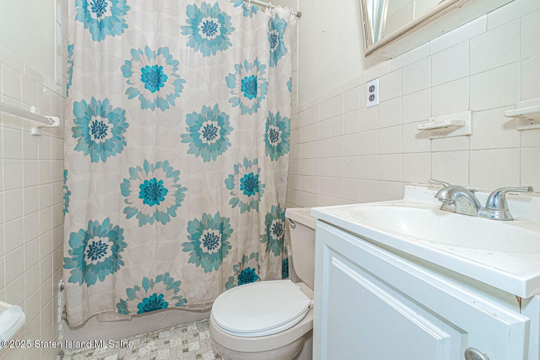 316 Sherman Street Brooklyn, NY 11218 - Photo 24 of 26 a bathroom with a sink a toilet and a mirror