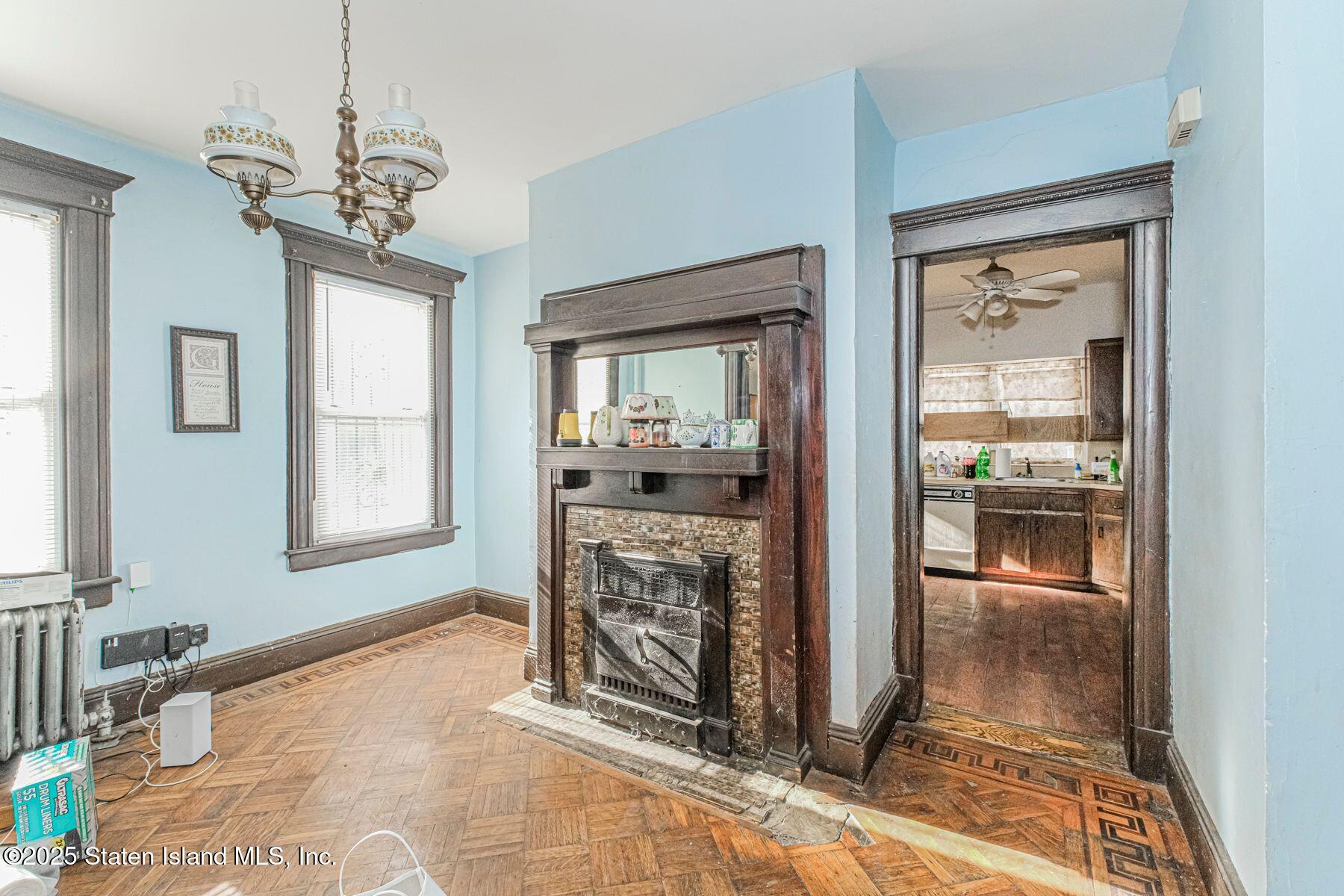 316 Sherman Street Brooklyn, NY 11218 - Photo 6 of 26 a dining room with chandelier fan and wooden floor