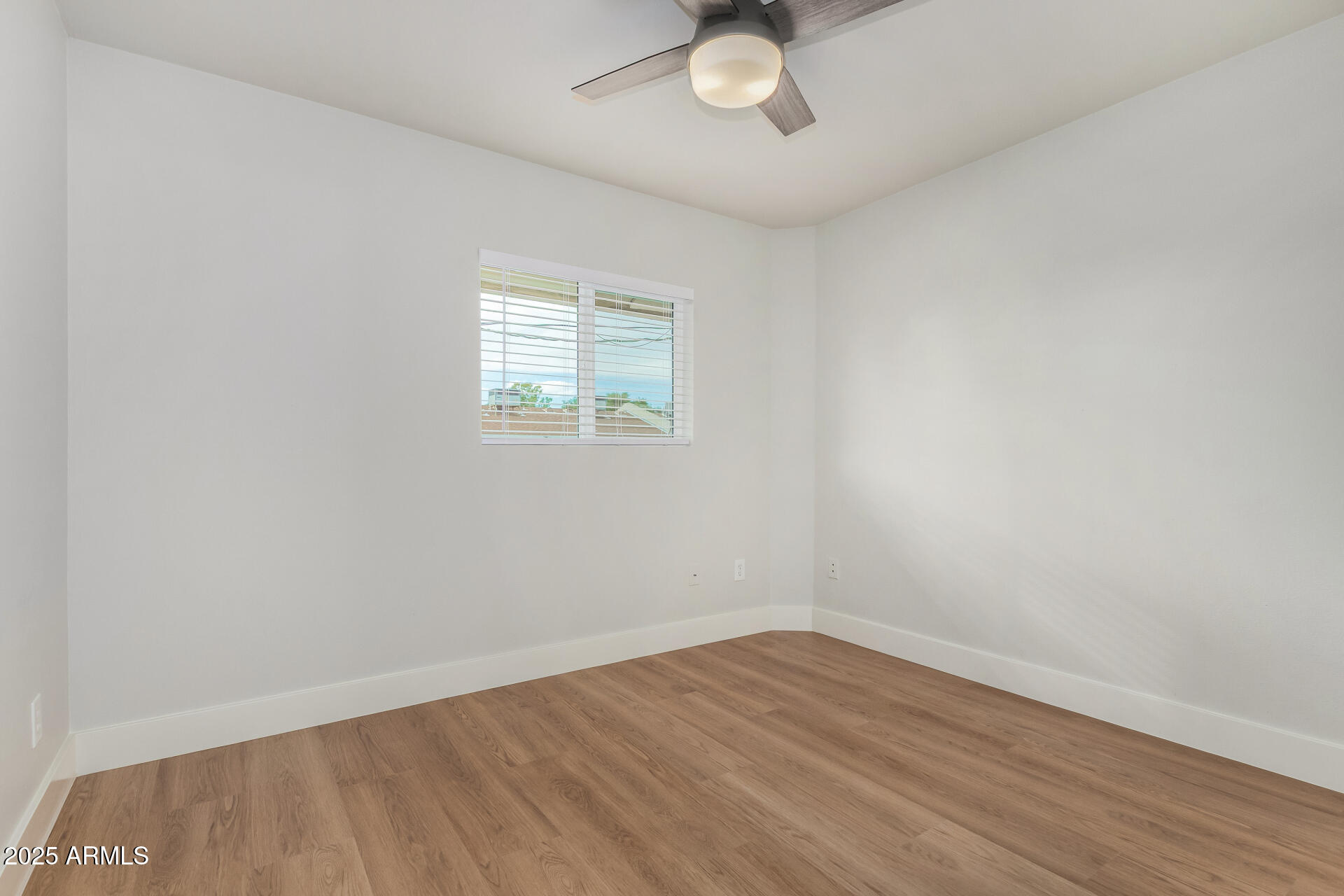 6027 North Granite Reef Road Scottsdale, AZ 85250 - Photo 12 of 29 wooden floor in an empty room with a window