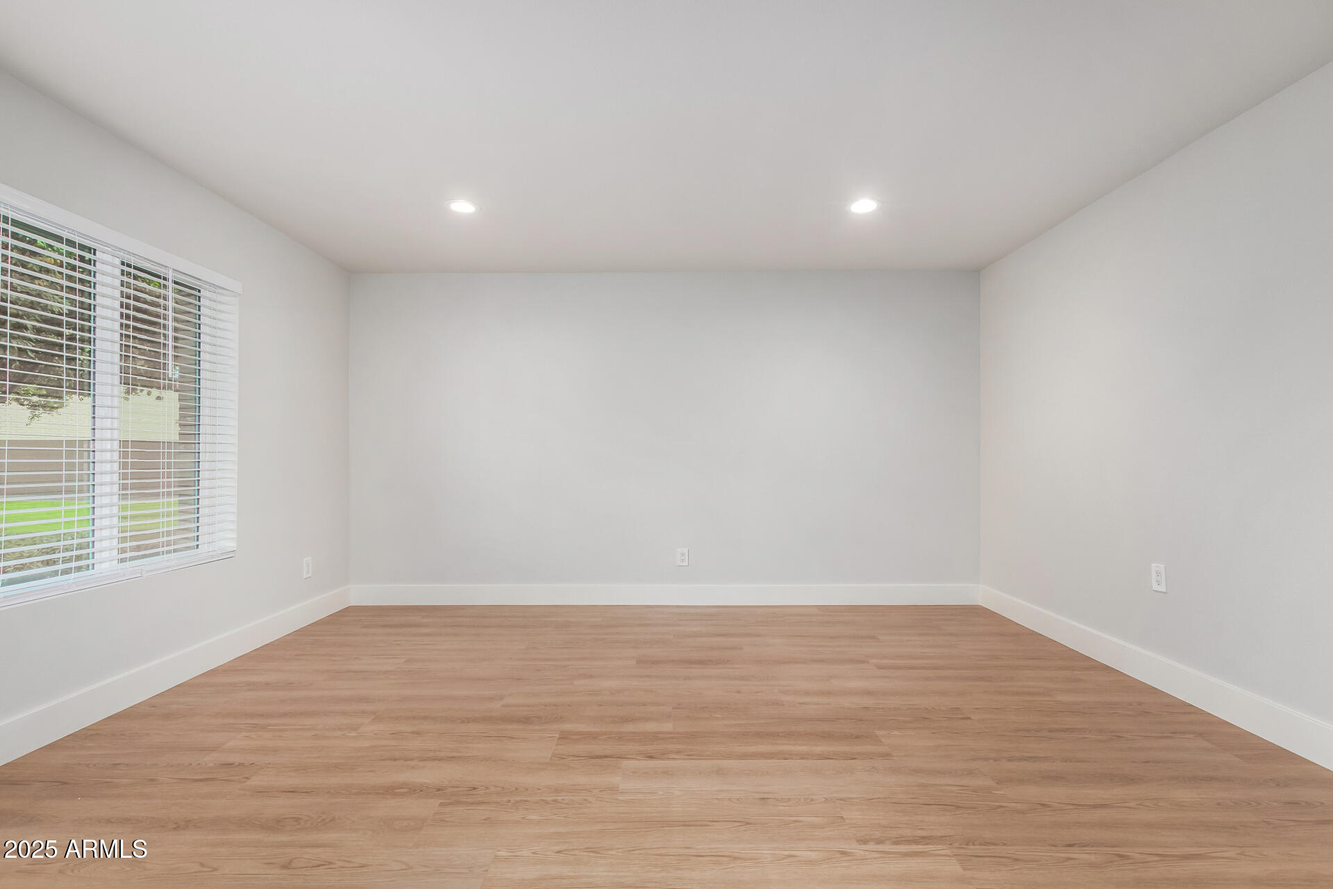 6027 North Granite Reef Road Scottsdale, AZ 85250 - Photo 4 of 29 an empty room with wooden floor and windows