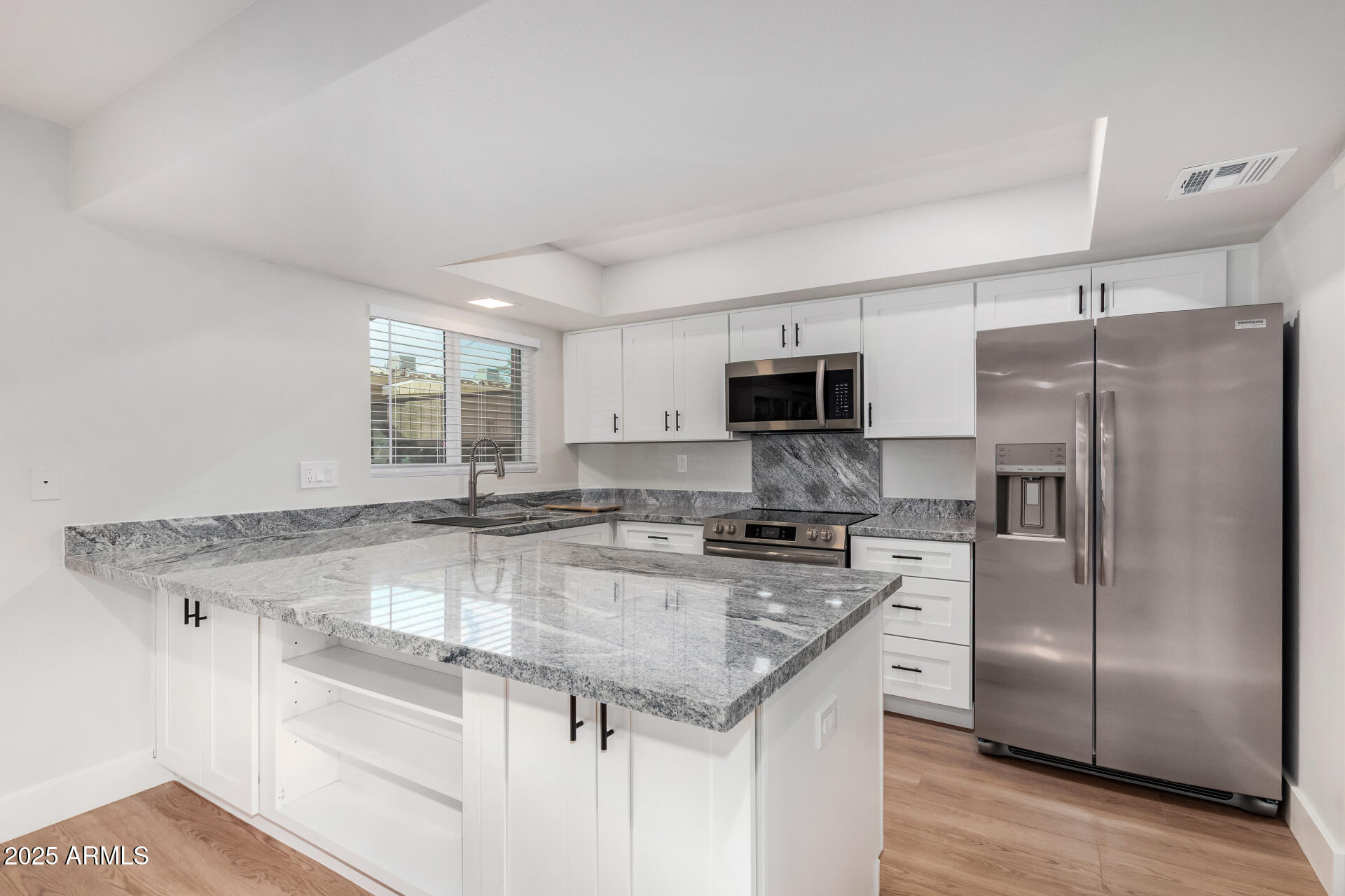 6027 North Granite Reef Road Scottsdale, AZ 85250 - Photo 7 of 29 a kitchen with stainless steel appliances granite countertop a sink stove and refrigerator
