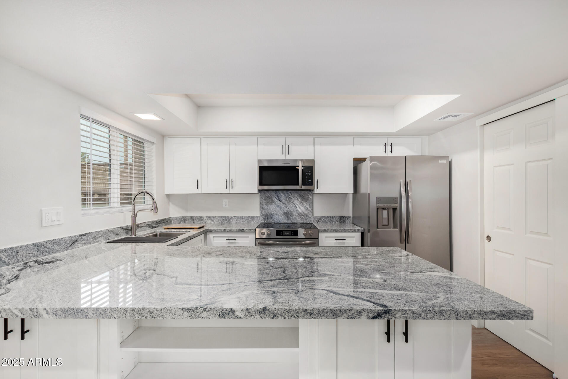 6027 North Granite Reef Road Scottsdale, AZ 85250 - Photo 8 of 29 a kitchen with stainless steel appliances granite countertop a sink stove and refrigerator